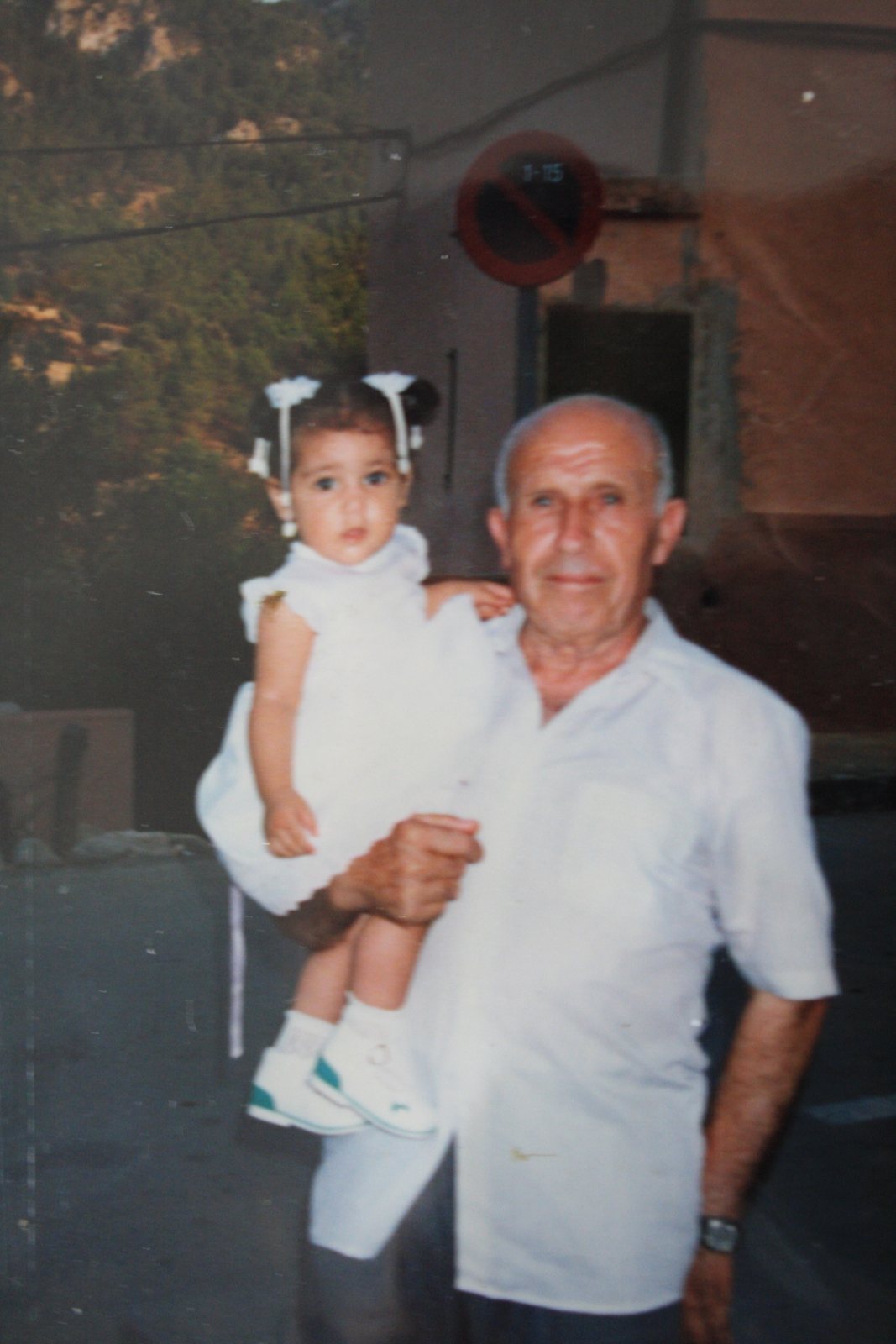 Shereen as a baby, held by her grandfather on a village street